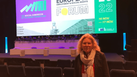 Picture of Irene Giner Reichl, with conference poster in the background