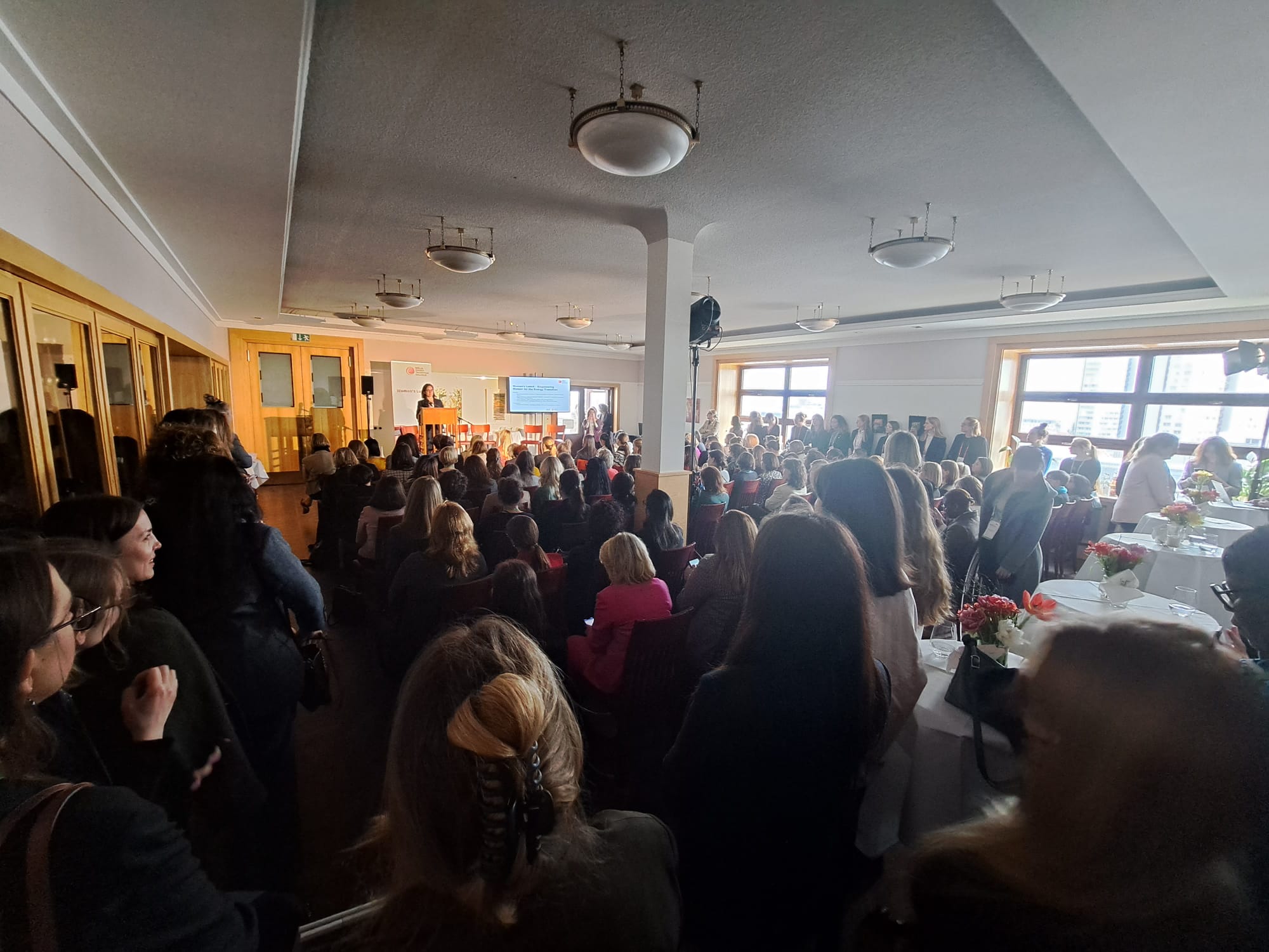 Image taken from the back of a full meeting room with participants seated