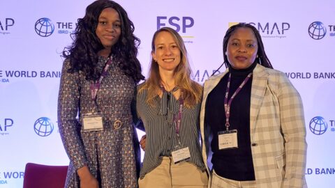 Three women standing on stage facing the camera